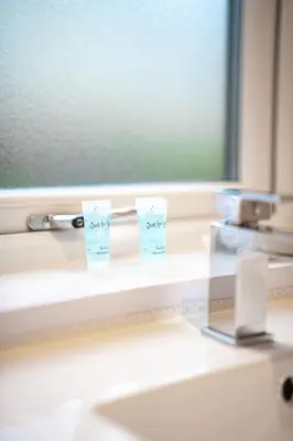 a bathroom sink with two toothbrushes and a mirror at Bonnie Apartment in Coatbridge