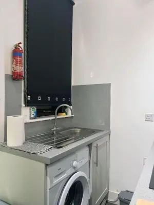 a kitchen with a sink and a washing machine at King Apartment in Falkirk