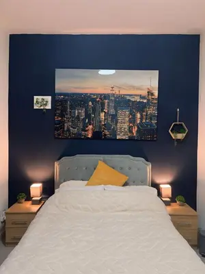 a bedroom with a large white bed with a picture on the wall at King Apartment in Falkirk