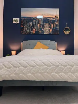 a bedroom with a white bed with a picture on the wall at King Apartment in Falkirk