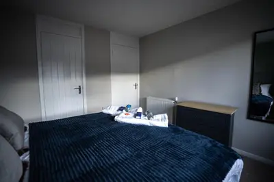 a bedroom with a bed with a blue comforter at Bank House in Livingston