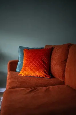 an orange pillow sitting on a brown couch at Bank House in Livingston