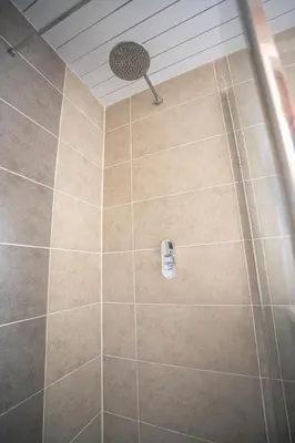 a shower with a shower head in a bathroom at Muirhead House in Motherwell