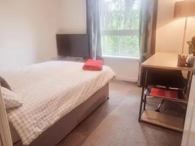 a small bedroom with a bed and a window at Modern Two Bed Glasgow Apartment with Free Parking in Glasgow