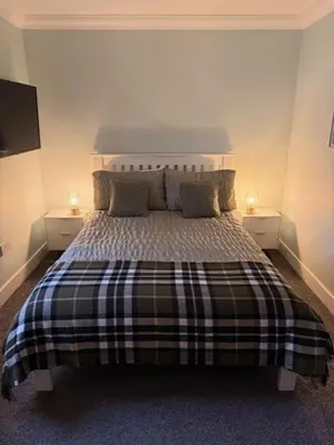 a bedroom with a large bed with two night stands at Gellyburn Cottage in Kinross