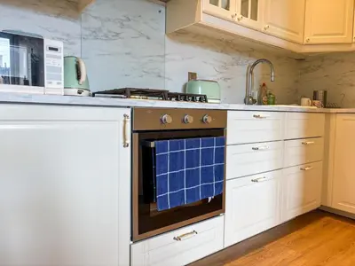 a kitchen with an oven with a blue towel on it at Bright Top Floor 2BR Apartment in Morningside, Easy City Centre Links, Close to University and Royal Hospital in Edinburgh