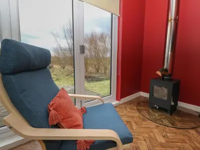 a living room with a chair and a fireplace at Tirlaggan Studio in Oban