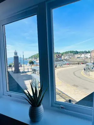 a window with a view of a clock tower at Kilmartin Court Apartments - No3 By The Sea & No2 With A View - free parking in Oban