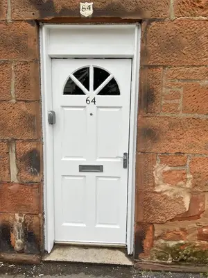 a white door in a brick wall at Apartment Caerlaverock Road in Prestwick