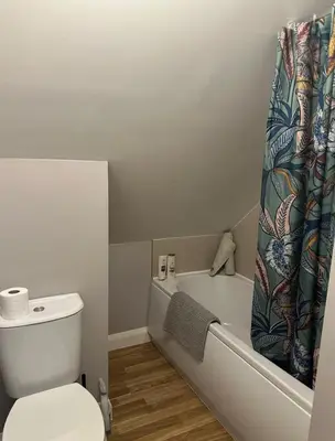 a bathroom with a tub and a toilet and a shower curtain at Charming Snug Loft Room, Room 4, Beautiful Connel near Oban in Connel