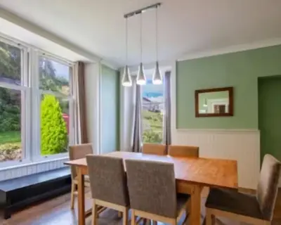 a dining room with a wooden table and chairs at Charming Snug Loft Room, Room 4, Beautiful Connel near Oban in Connel