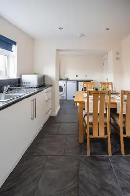 a kitchen and dining room with a table and chairs at 3-Bed Home Near Town Center in Stirling