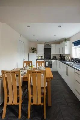 a kitchen with a wooden table and some chairs at 3-Bed Home Near Town Center in Stirling