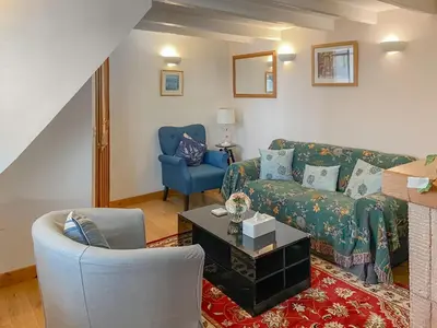 a living room with a couch and a chair at Cosy Cottage in Lamlash