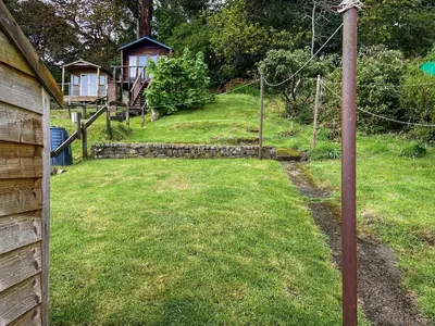 a yard with a fence and a house at Cosy Cottage in Lamlash