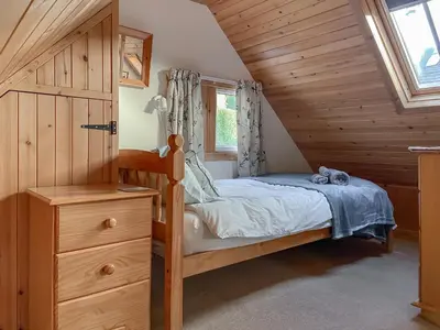 a small bedroom with a bed and a window at Cosy Cottage in Lamlash