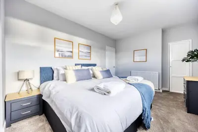 a bedroom with a large white bed and a desk at Charming Terrace House for Relaxing Retreat in Dumbarton