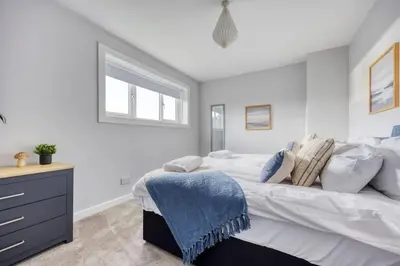 a bedroom with a large bed and a window at Charming Terrace House for Relaxing Retreat in Dumbarton