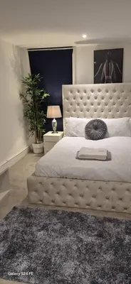 a bedroom with a large bed with a large headboard at Apartment In Canary Wharf, London in Moffat
