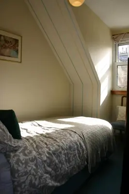 a bedroom with a bed and a window at Church Cottage with sunny garden in Ayr