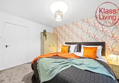 a bedroom with a large bed with orange pillows at Colt Apartment by Klass Living Coatbridge in Glenboig