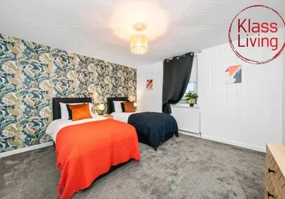 a bedroom with two beds with orange and black at Colt Apartment by Klass Living Coatbridge in Glenboig