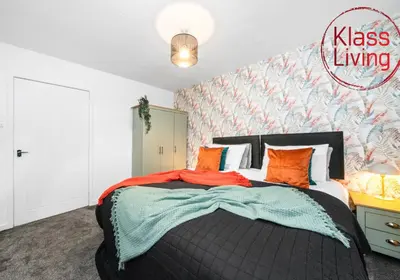 a bedroom with a large bed with orange pillows at Colt Apartment by Klass Living Coatbridge in Glenboig