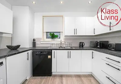 a kitchen with white cabinets and a black dishwasher at Colt Apartment by Klass Living Coatbridge in Glenboig