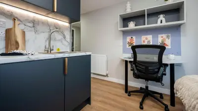a kitchen with a desk and a chair next to a bed at For Students Only Clyde Court Glasgow in Glasgow