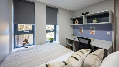 a bedroom with a bed and a desk and windows at For Students Only Clyde Court Glasgow in Glasgow