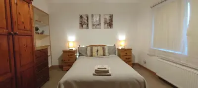 a bedroom with a bed with two night stands and two lamps at Rustic Harmony - Edinburgh Airport near, 8mi in Rosyth