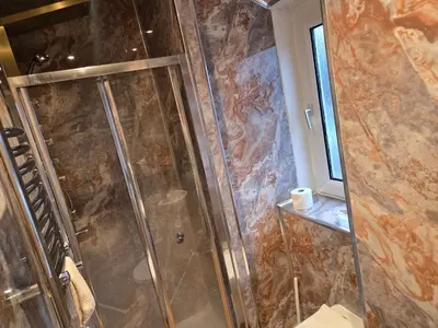 a shower with a glass door in a bathroom at Rustic Harmony - Edinburgh Airport near, 8mi in Rosyth