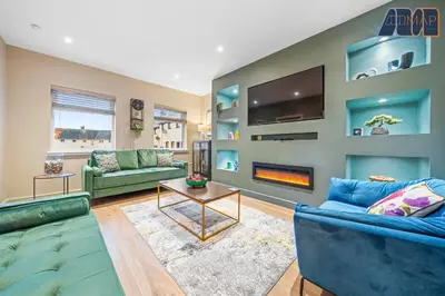a living room with blue couches and a tv at 3Bed Home Sleeps 6 w Private Parking in Dunfermline