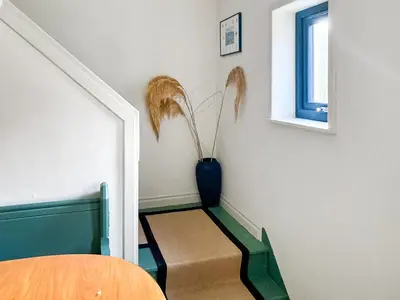 a stairway with a blue vase and a chair at Alt Na Blathaich in Coirantee