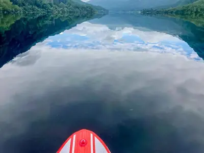 a red boat in the middle of a body of water at Alt Na Blathaich in Coirantee