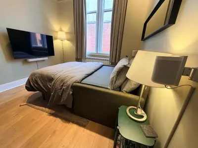 a small bedroom with a bed and a lamp at Quiet City Centre, King & Sofa Bed in Glasgow