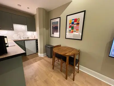 a kitchen with a wooden table and a kitchen with a counter at Quiet City Centre, King & Sofa Bed in Glasgow