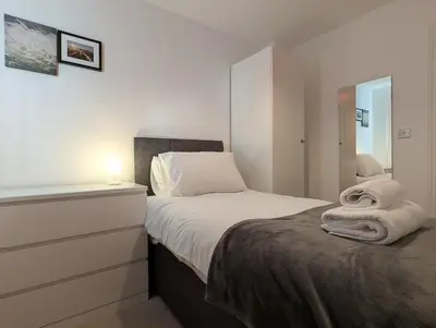 a bedroom with a bed with towels on it at Pilmuir Apartment 3 bed 2 bath in Dunfermline