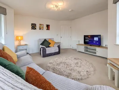 a living room with a couch and a tv at Pilmuir Apartment 3 bed 2 bath in Dunfermline