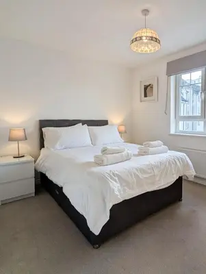 a bedroom with a large bed with two towels on it at Pilmuir Apartment 3 bed 2 bath in Dunfermline