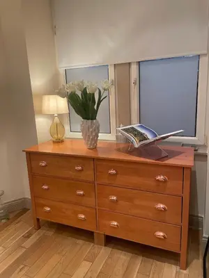 a dresser with a vase of flowers on top of it at Glasgow City - Large Stylish 2 Bed Flat in Unique Ibrox Location Walking Distance to Subway and Free On-Street Parking in Glasgow