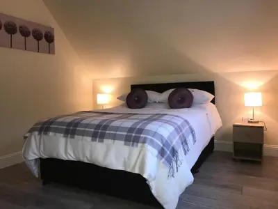 a bedroom with a large bed with two donuts on it at Mountain View Self Catering Ballachulish Glencoe in North Ballachulish