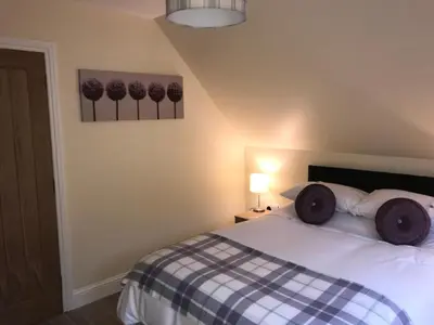 a bedroom with a bed with a checkered blanket at Mountain View Self Catering Ballachulish Glencoe in North Ballachulish