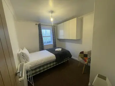 a small bedroom with a bed and a window at Campbell Cottage in Biggar