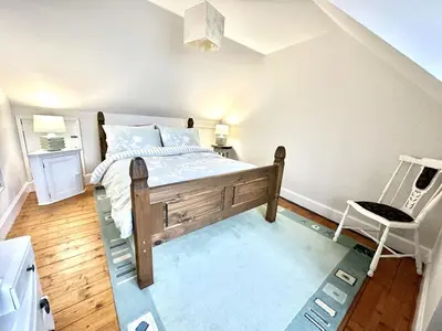a bedroom with a bed and a chair in it at Traditional Inveraray Cottage - Amazing Loch Views in Inveraray