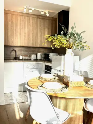 a kitchen with a table with white chairs and a counter at Castlegreen Lux Apartment in Dumbarton