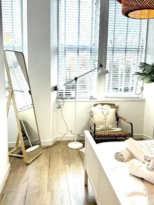 a bedroom with a bed and a lamp and a chair at Castlegreen Lux Apartment in Dumbarton