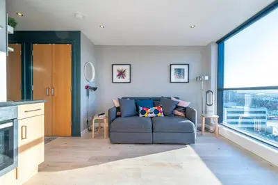 a living room with a couch and a large window at Stylish Studio Finnieston City Centre Free Parking in Glasgow
