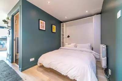 a bedroom with a large bed and a blue wall at Stylish Studio Finnieston City Centre Free Parking in Glasgow
