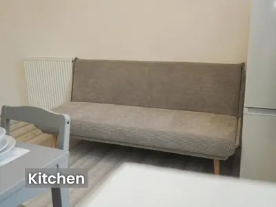 a brown couch in a room with a table at Edinburgh Modern Apartment in Haymarket, city centre in Edinburgh